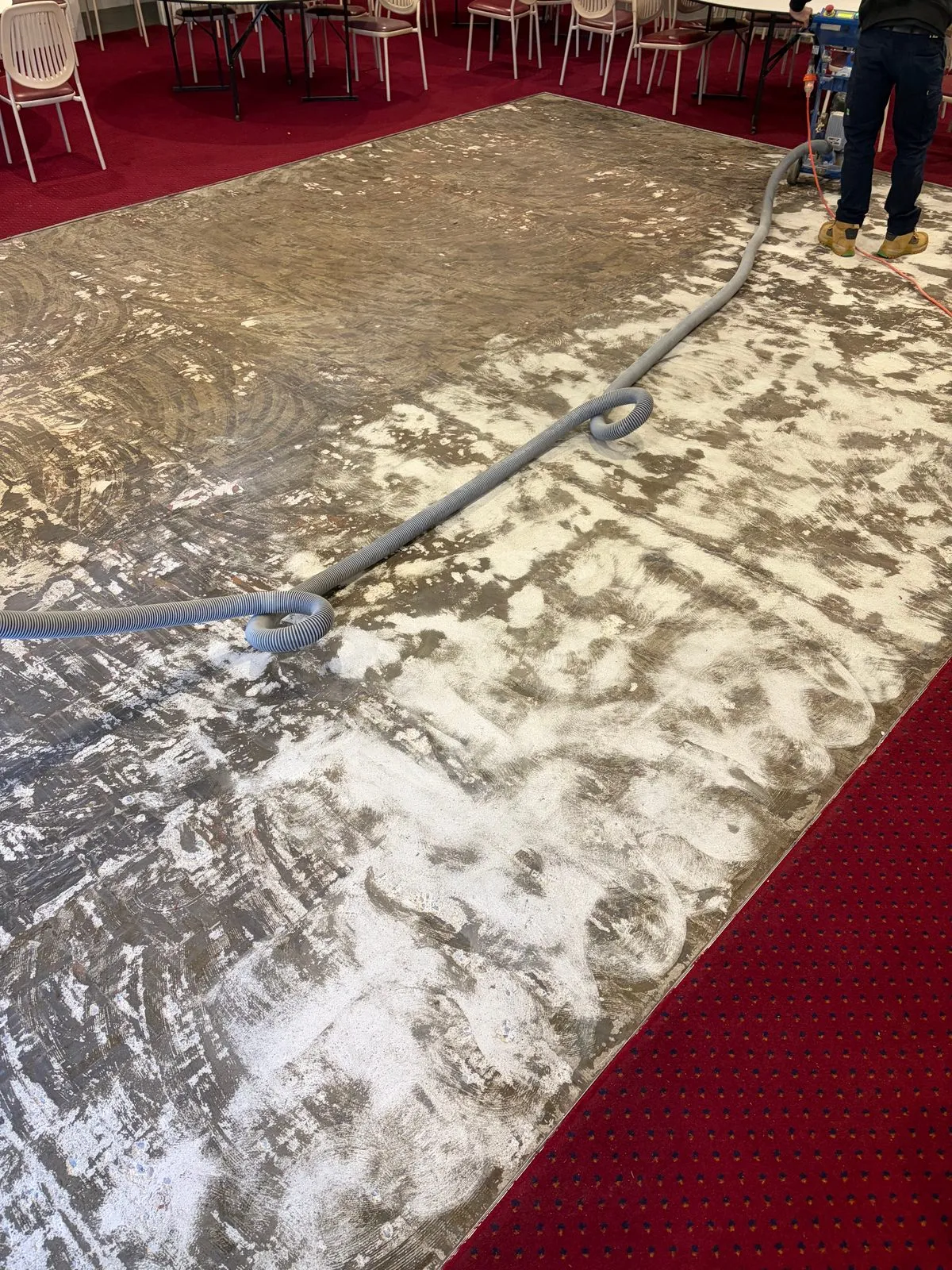 Concrete subfloor being ground and prepared before flooring installation